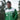 Man wearing a green Atlético Nacional track jacket with white chest panel and full zip, featuring Postobón sponsor logo and club crest, standing outdoors.