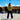 Woman wearing a retro Peñarol football shirt with Volkswagen sponsor, standing outside a stadium under a blue sky.

