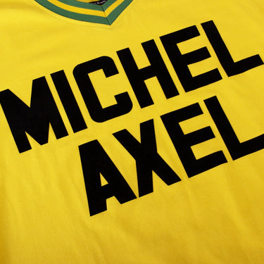 FC Nantes 1972 - 73 Retro Football Shirt Close-up focusing on the "MICHEL AXEL" sponsor text printed in bold black letters on yellow fabric.