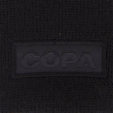 Embroidery detail of the tonal COPA logo patch on the black cuff of the beanie