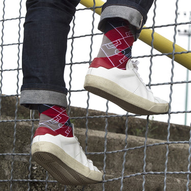 model wearing casual red socks with argyle pattern and football pitch markings