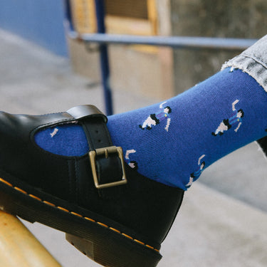 model wearing casual blue socks with a repeating pixel-style illustration of maradona