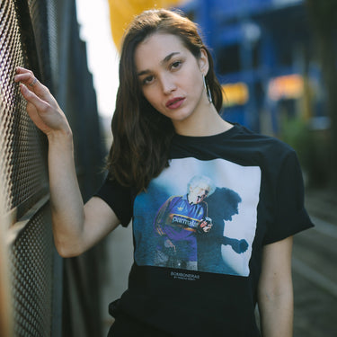 Model wearing the Bomboneras T-Shirt, showcasing the design in an urban setting with stylish football-inspired fashion.