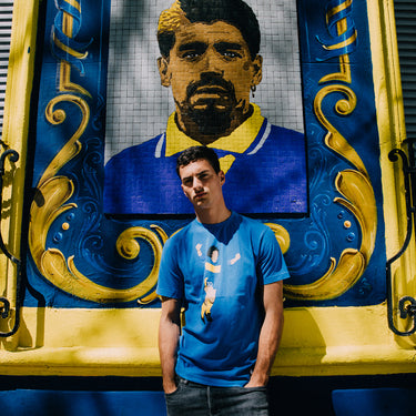 Maradona X COPA Boca Graphic T-Shirt Blue & Yellow featuring an abstract illustration of Maradona celebrating in Boca Juniors colors.