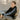 Model sitting outdoors wearing the black COPA hoodie with visible sleeve branding.