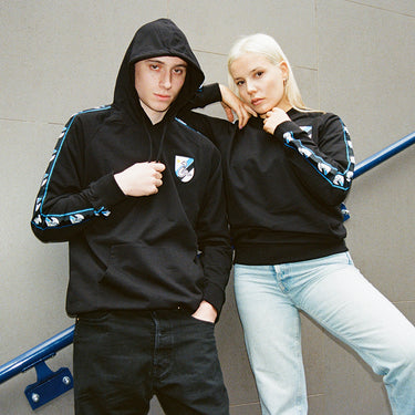 Two models wearing the FC Internazionale Taper Hooded Sweater, showcasing the Biscione ribbon detail on the sleeves.
