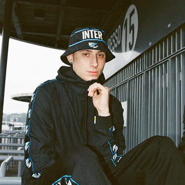 Young man wearing the black Inter Milan windbreaker in a stadium setting