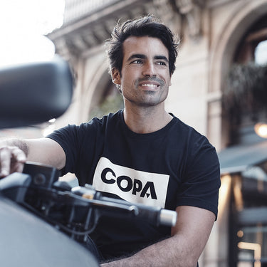 A model wearing the COPA Box Logo T-Shirt, posing with a relaxed expression outdoors.