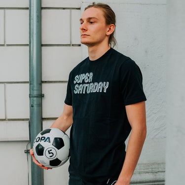 Model wearing the Super Saturday T-Shirt outdoors, showcasing its casual fit and style.